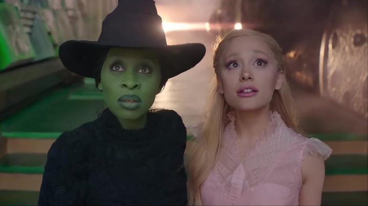 Cynthia Erivo and Arianda Grande stand next to each other and stare in a still from the movie Wicked.