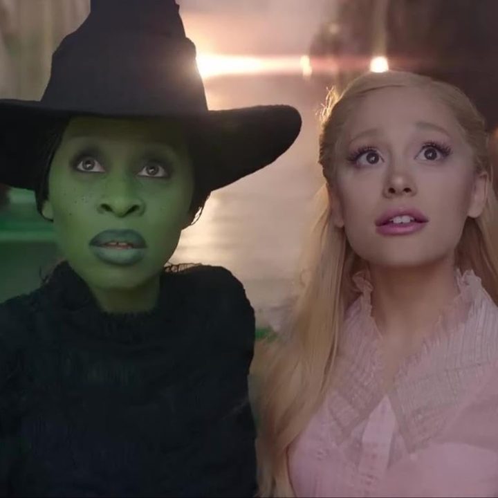 Cynthia Erivo and Arianda Grande stand next to each other and stare in a still from the movie Wicked.