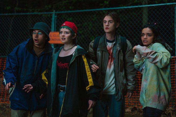 A group of four kids stand next to each other in Y2K.