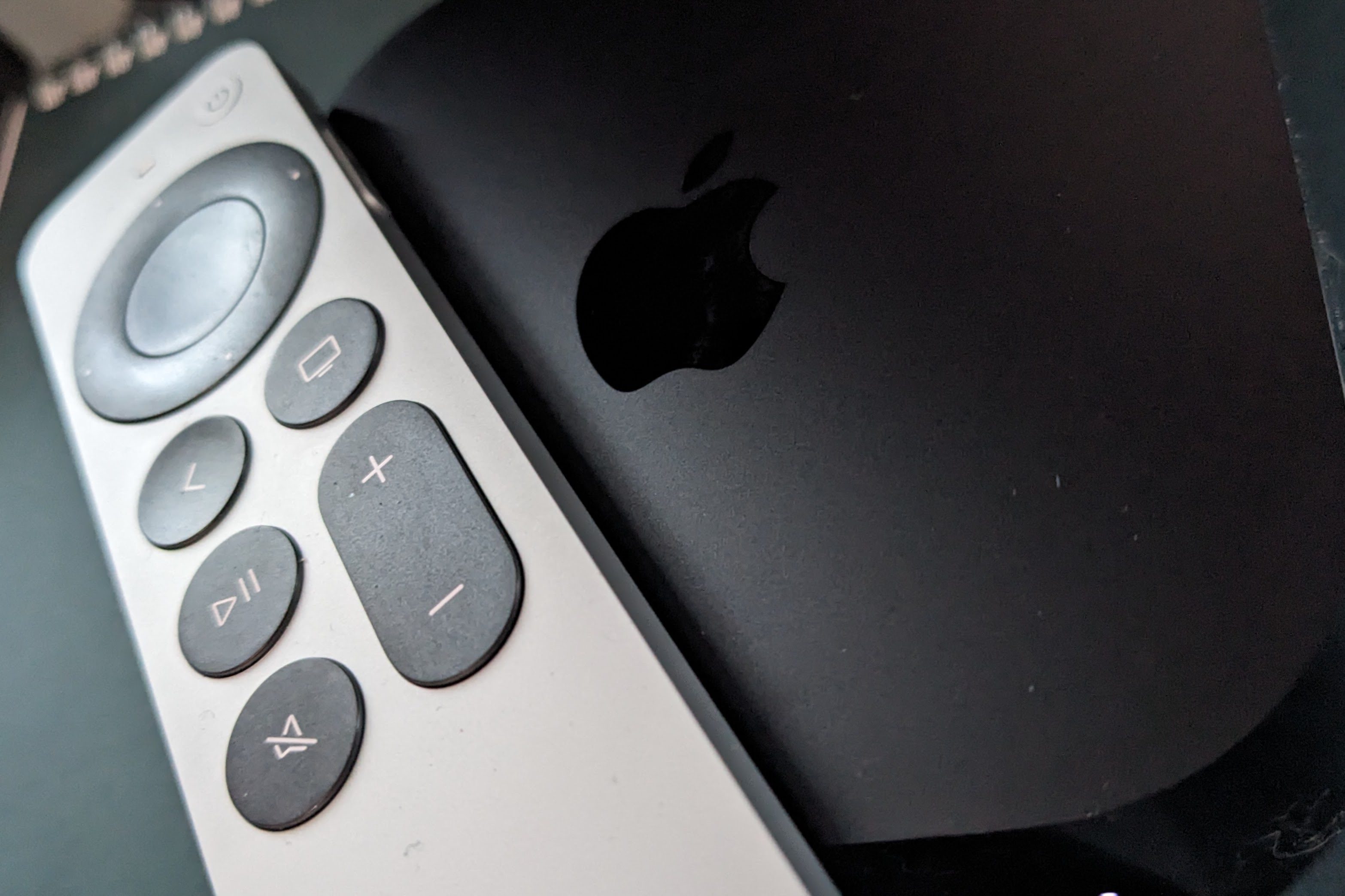 An Apple remote sits on top of an Apple TV 4k.