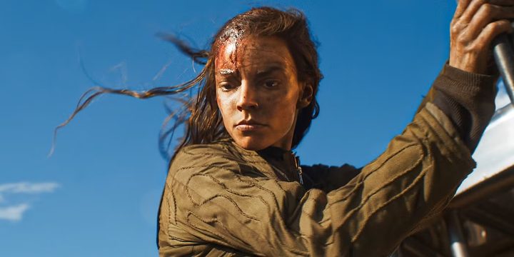 A woman looks down in Furiosa.
