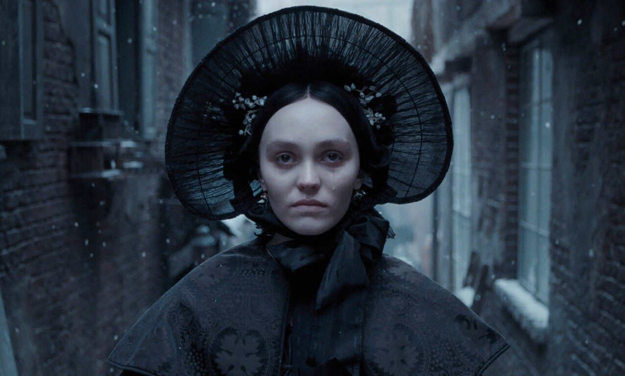 A woman stands in a street in Nosferatu.