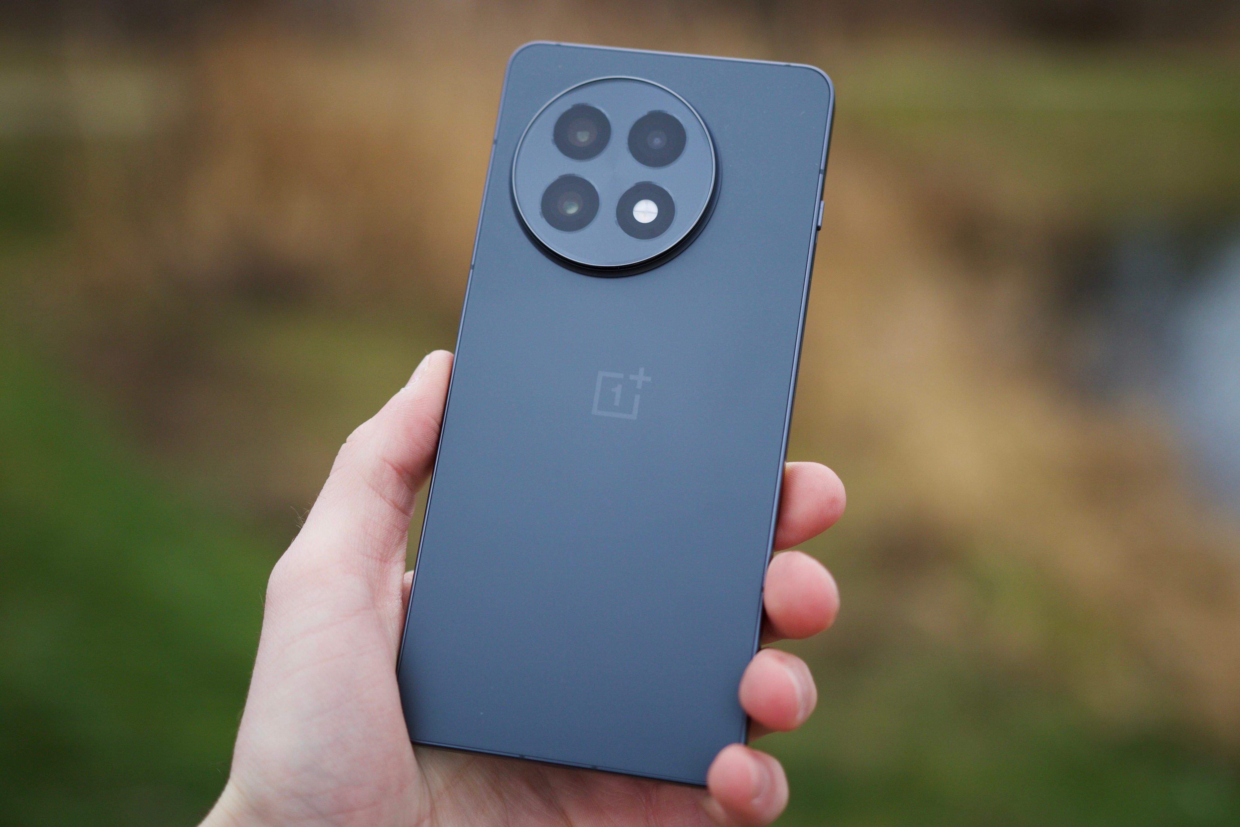 Someone holding the OnePlus 13R, showing the back of the phone.