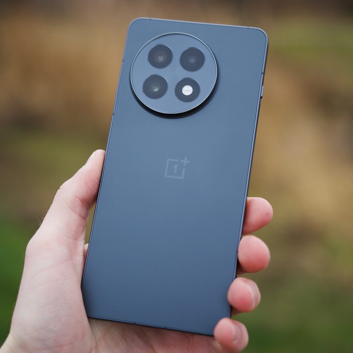 Someone holding the OnePlus 13R, showing the back of the phone.