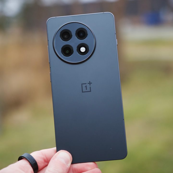 Someone holding the OnePlus 13R, showing the back of the phone.