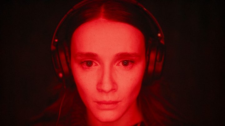 A woman stares at the camera in Red Rooms.