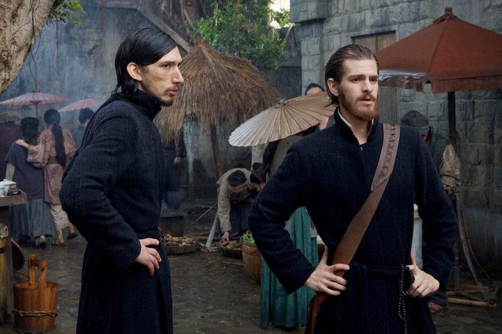 Two priests stand in a village in Silence.