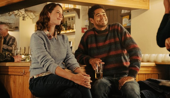 A man and a woman smile in This is Christmas.