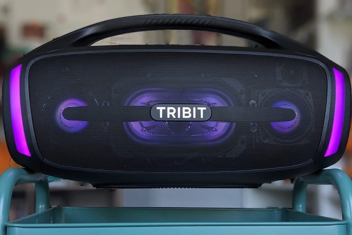 The Tribit StormBox Blast 2 speaker balanced on a cart. It's LED lights are lit up purple.