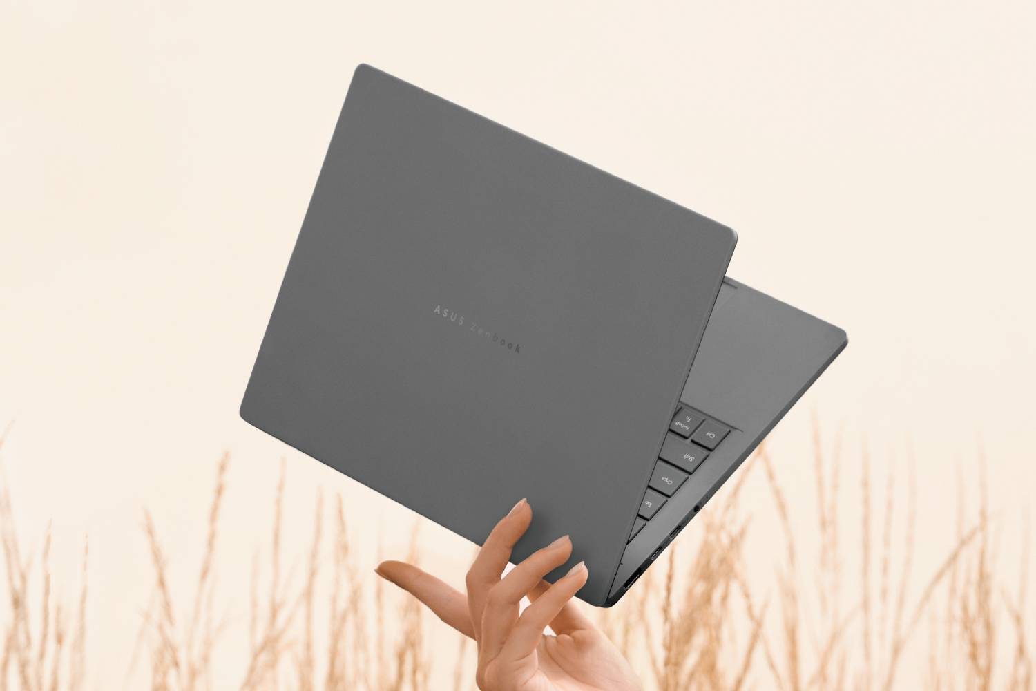 دستی که Zenbook A14 را بین انگشتان خود نگه داشته است.