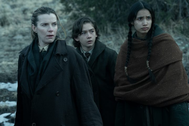 Betty Gilpin stands next to two young kids in American Primeval.