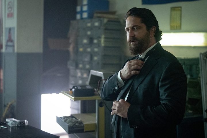 Gerard Butler as 'Big Nick' O'Brien fixes his tie in Den of Thieves 2.