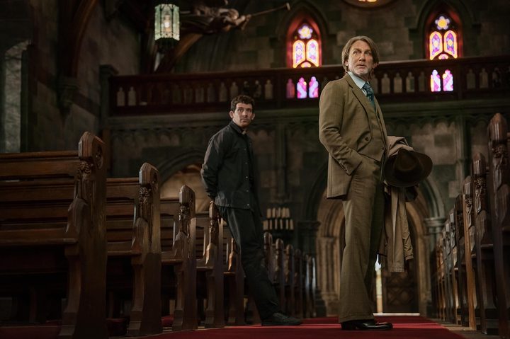 Daniel Craig and Josh O'Connor stand in a church in Knives Out 3.