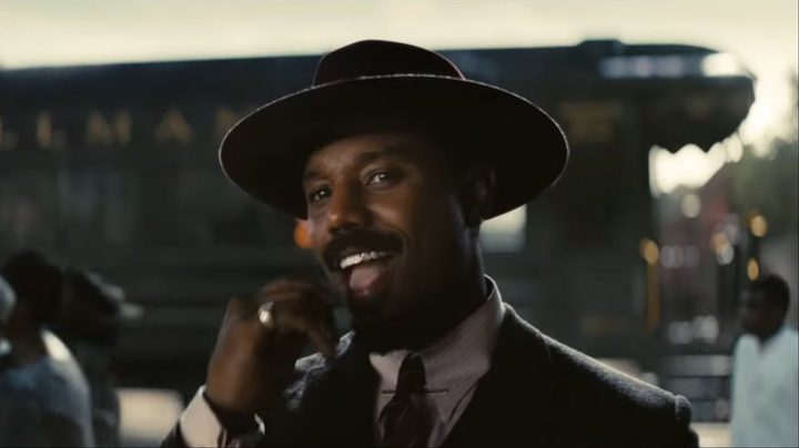 Michael B. Jordan puts a toothpick in his mouth in Sinners.