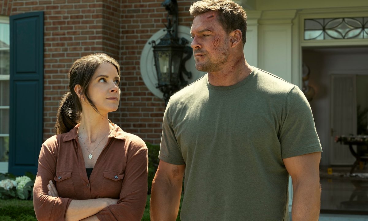 Jack Reacher stands next to a woman and stares in Reacher season 3.