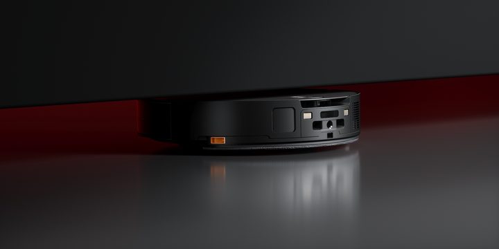 The Roborock Saros 10 navigating under a tight, low-clearance piece of furniture.