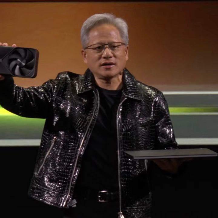 Nvidia CEO Jensen Huang holding an RTX 50 GPU and a laptop.