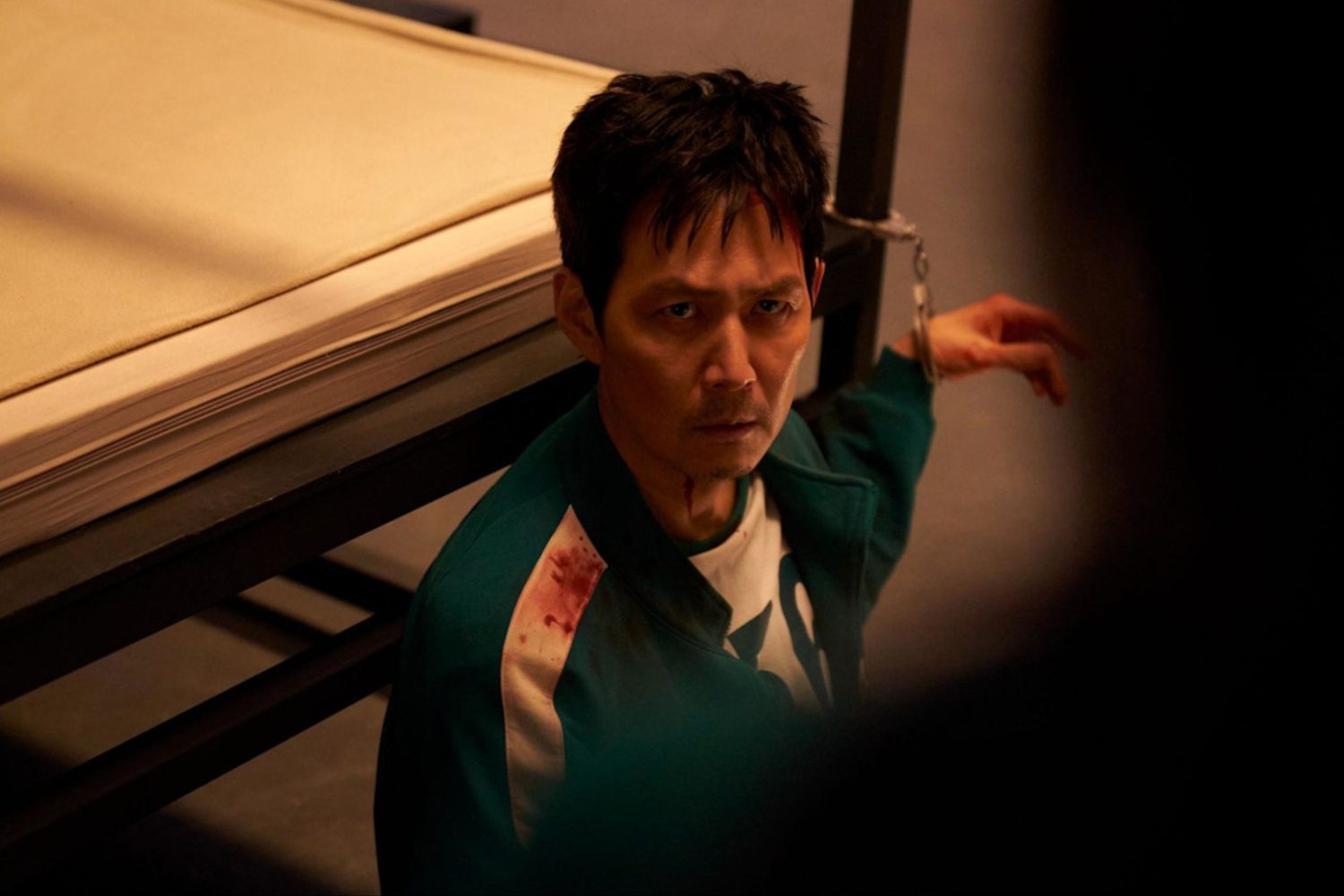 A man is handcuffed to a pole in Squid Game season 3.