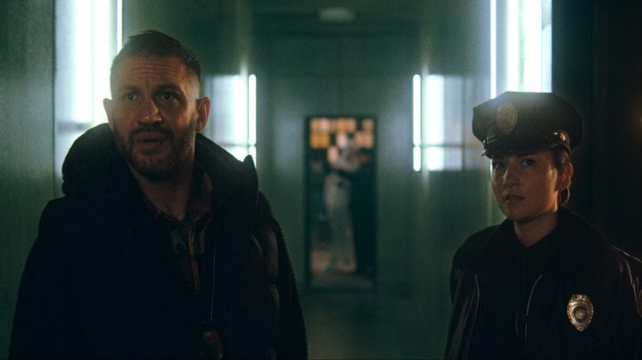 Tom Hardy stands next to a cop in Havoc.
