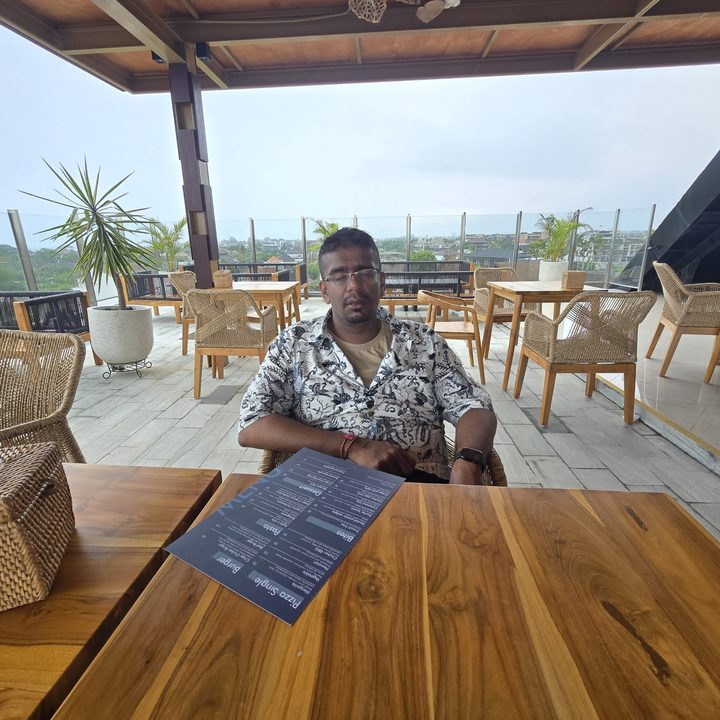An original photo of a person at a table with a menu in front of them