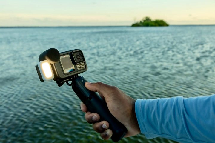 A person holding the GoPro HERO13 Creator Edition in front of the ocean.