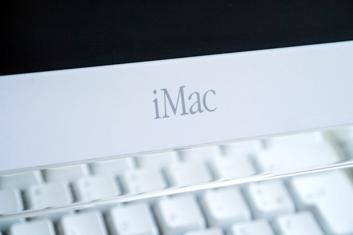 A close-up of an Apple iMac G4 showing the "iMac" logo.