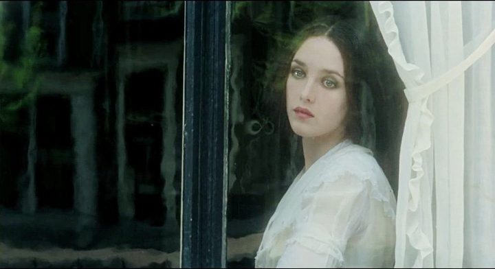 A woman looks out of a window in Nosferatu.