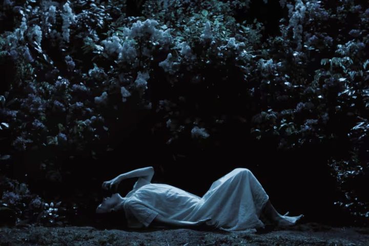 A woman lays on the ground at night in Nosferatu.