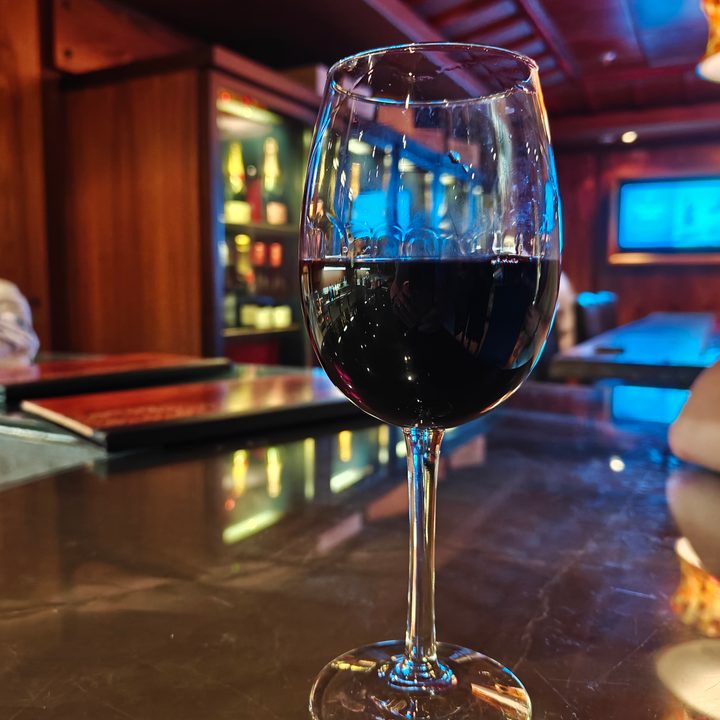 Photo of a glass of red wine in a bar, taken with the OnePlus 13R.