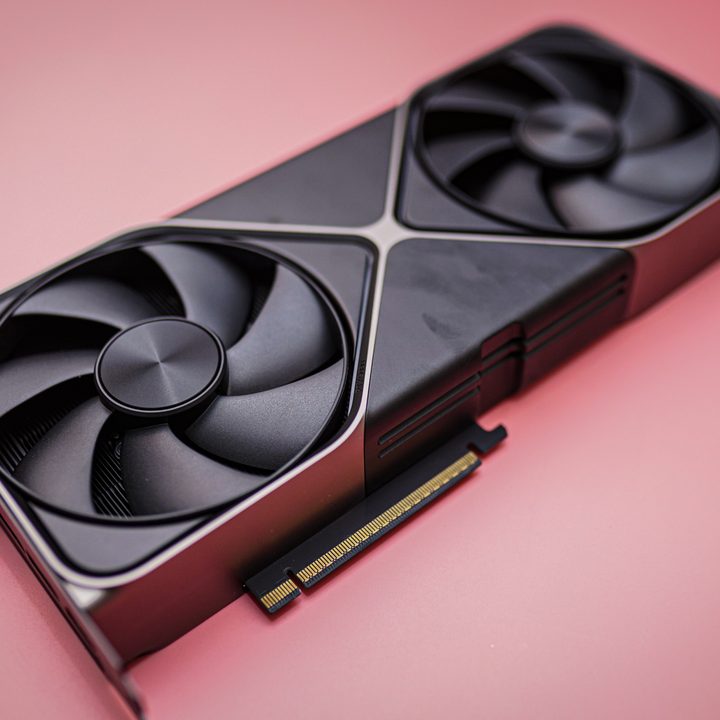 The RTX 5080 sitting on a pink background.