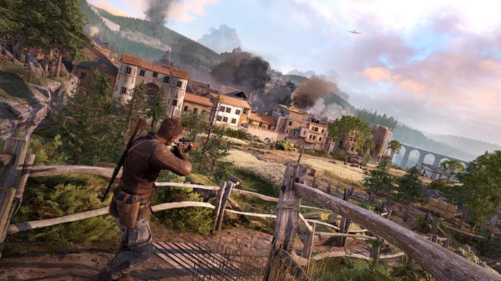 Harry Hawker surveys a town through a sniper scope in Sniper Elite: Resistance.