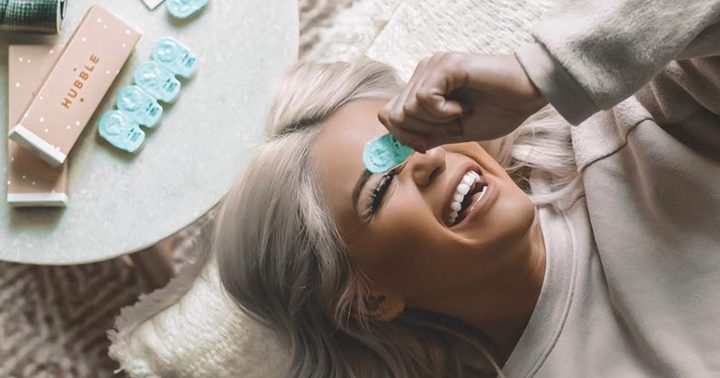 woman holding contact lense case over her face