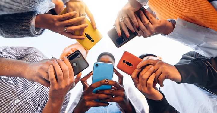 group of people in a circle holding their mobile phones