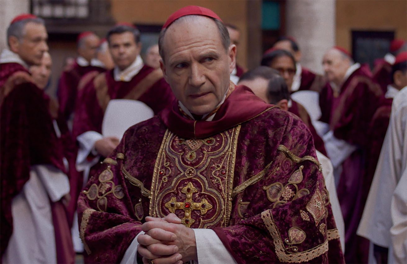 Ralph Fiennes stares in his clerical getup in a still from the movie Conclave.