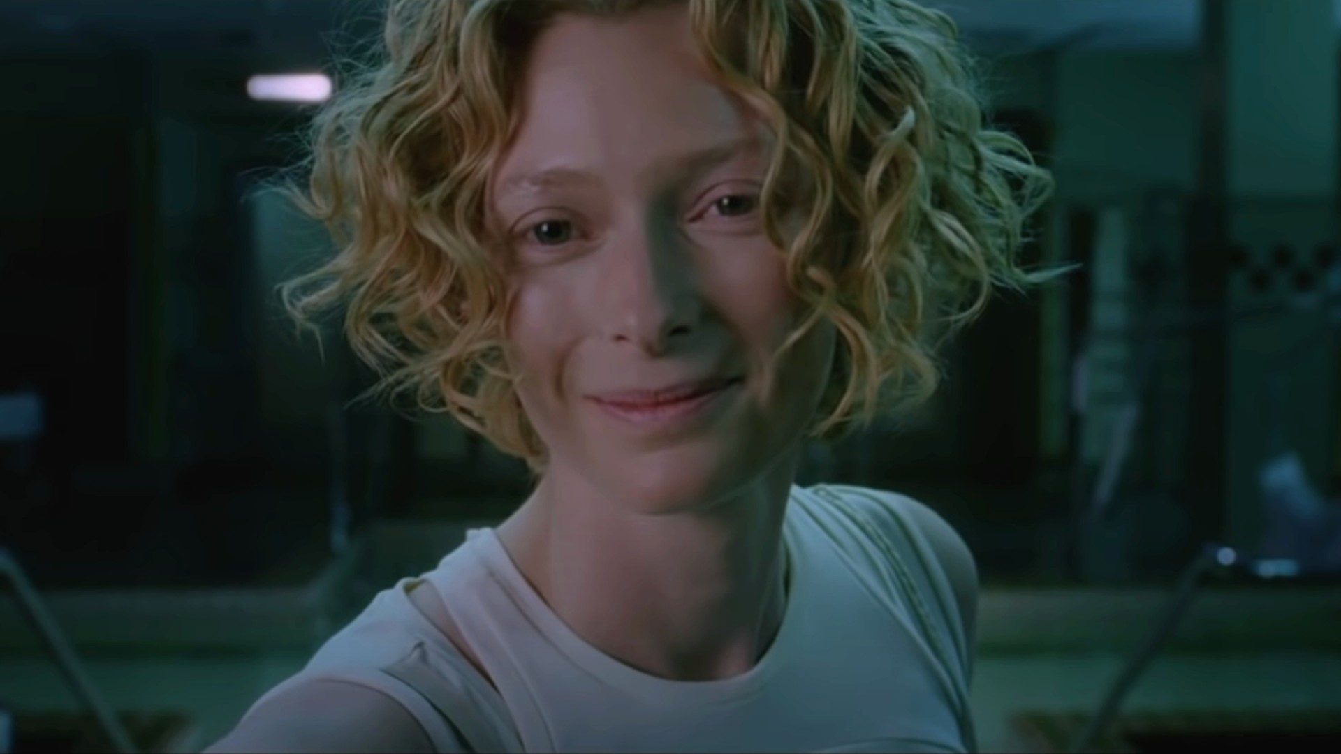 A young, blonde-locked Tilda Swinton smiles in close-up in a still from the movie Constantine.
