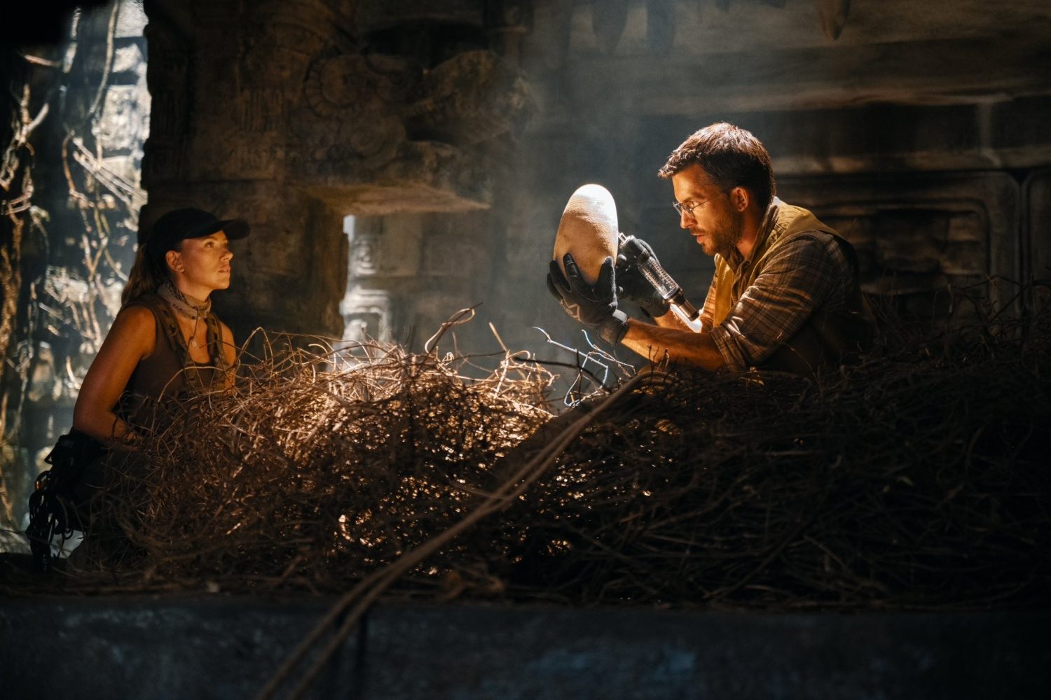 A man holds a dinosaur egg as a woman looks at him in "Jurassic World Rebirth."
