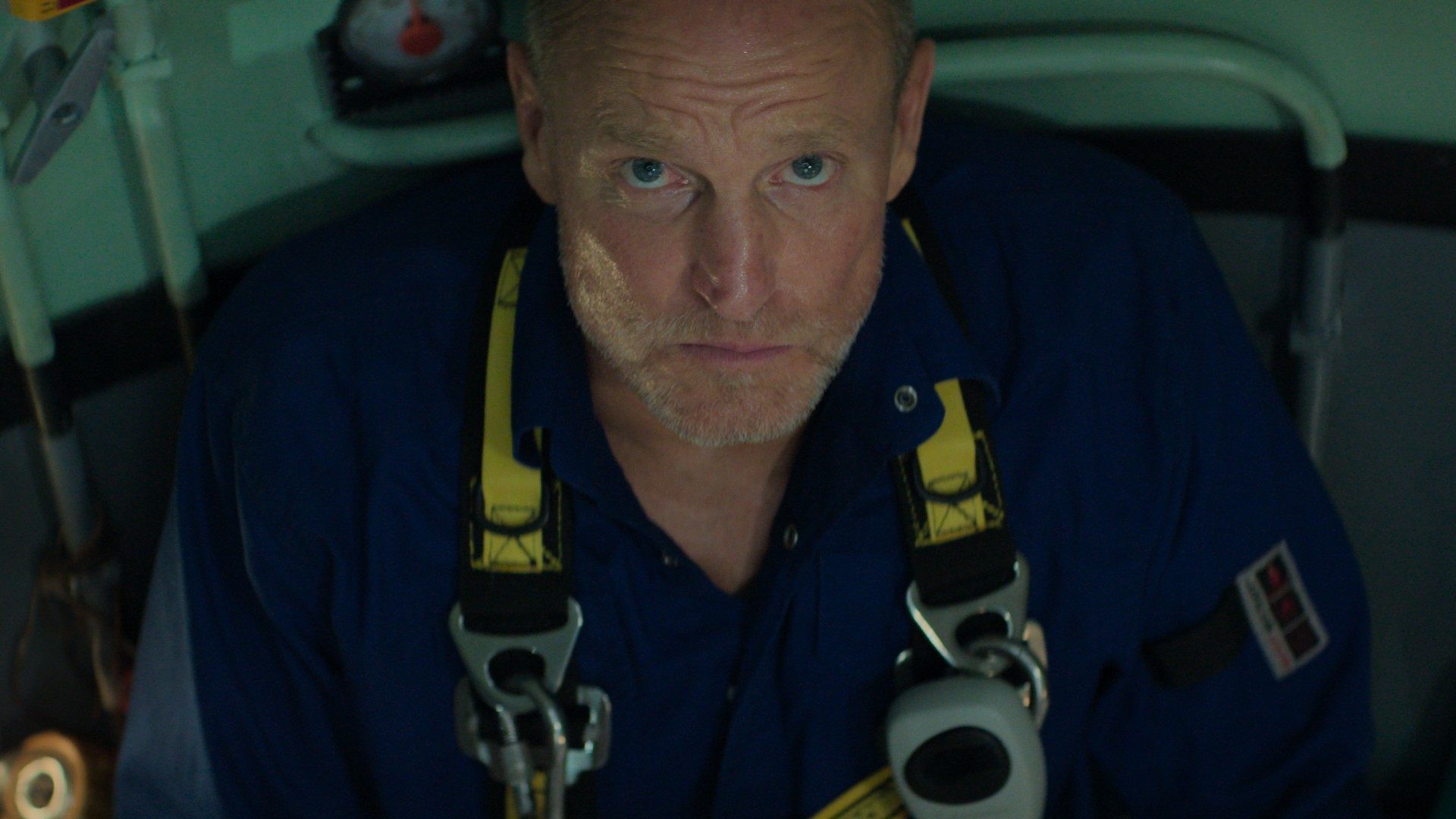 Woody Harrelson wears diving gear and looks up into the camera grimly in a shot from the movie Last Breath.