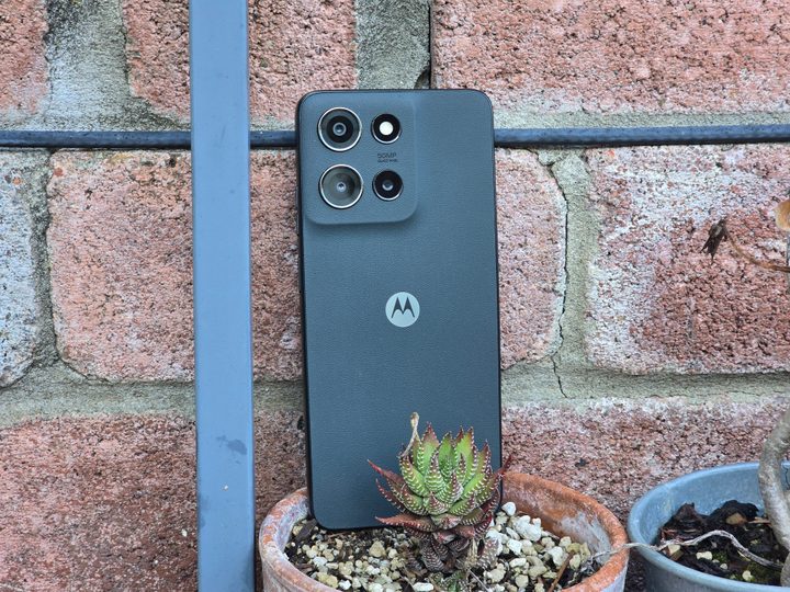 Moto G 2025 propped up behind a plant