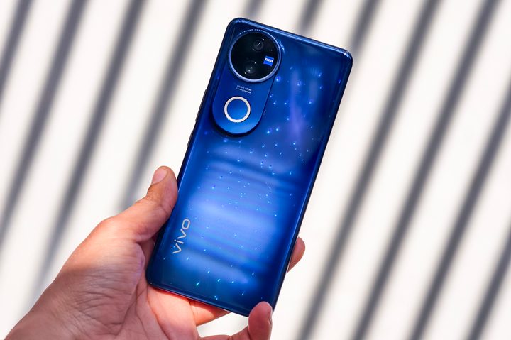 Vivo V50 celestial blue held in hand.