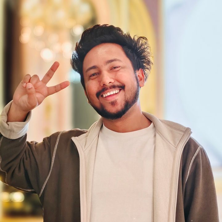 Portrait of a man standing in front of a bright stage setting shot on Vivo V50 with Zeiss effects and Aura Light.