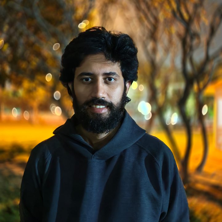 Portrait of a man standing in a park at night shot on Vivo V50 with Zeiss effects and Aura Light.