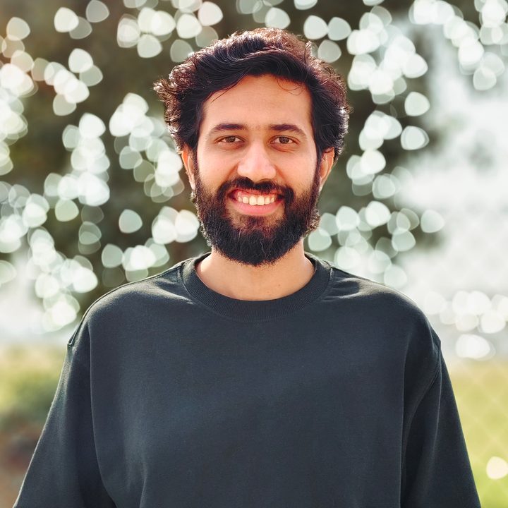 Portrait of a man standing in front of a tree foliage shot on Vivo V50 with Zeiss effects and Aura Light.