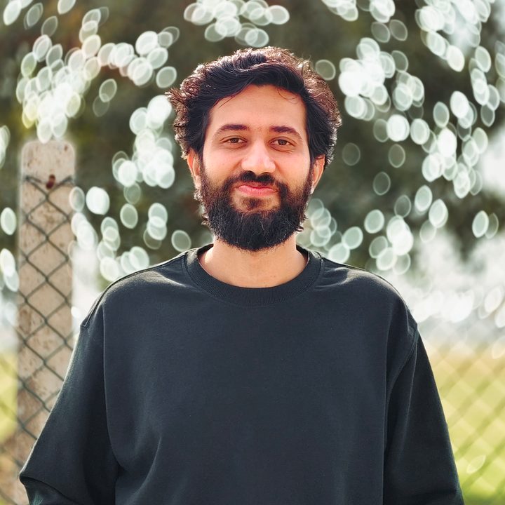 Portrait of a man standing in front of a tree foliage shot on Vivo V50 with Zeiss effects and Aura Light.