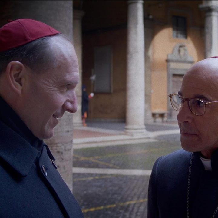 Ralph Fiennes and Stanley Tucci exchange words in a still from the movie Conclave