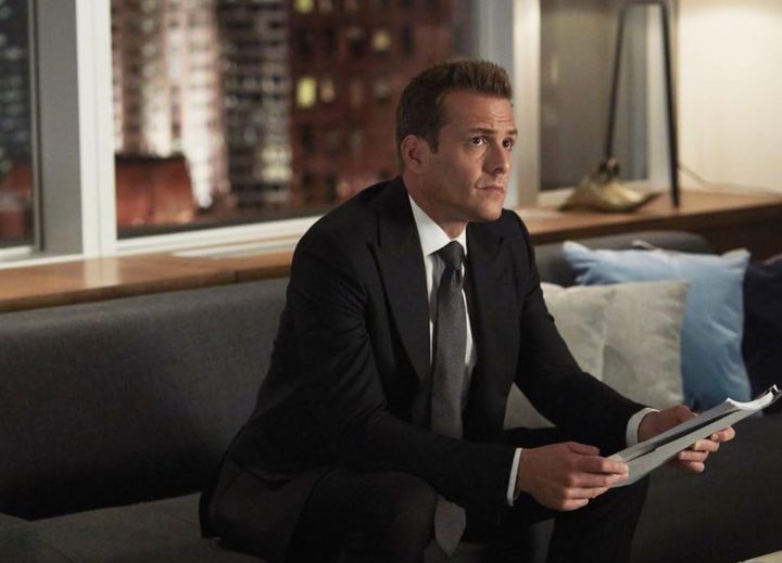 Gabriel Macht sits on a couch in Suits.