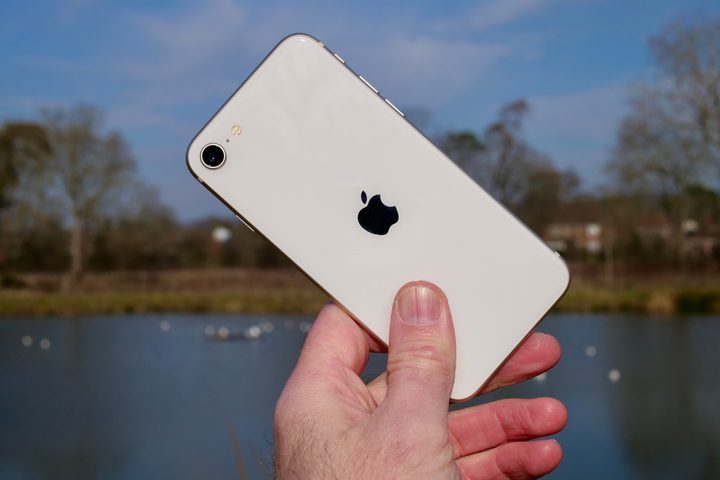 A person holding the The Apple iPhone SE (2022).