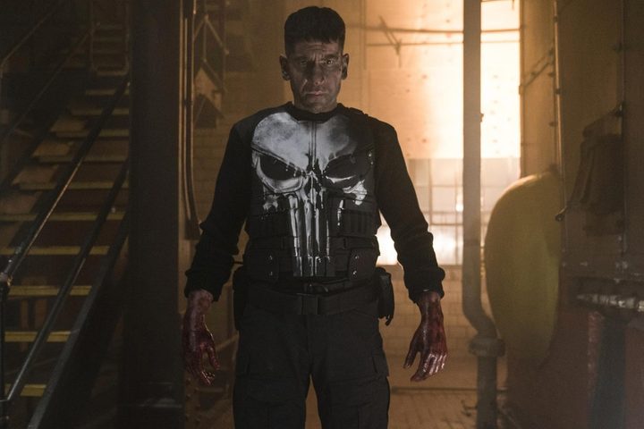 Jon Bernthal stands as the Punisher and stares.
