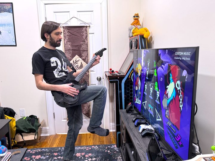 A man plays Rift of the Necrodancer with a PDP Riffmaster.