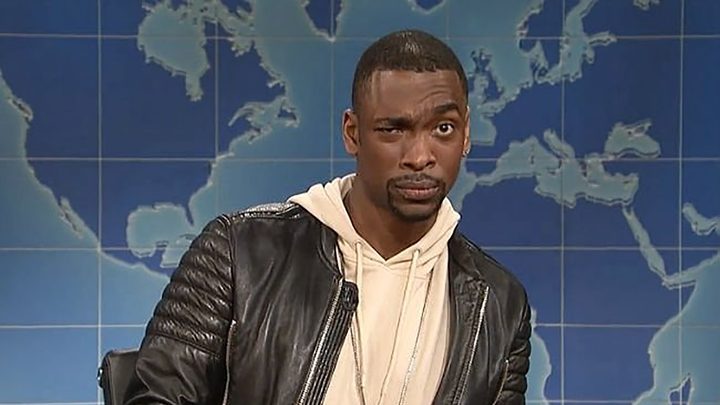 Jay Pharoah on SNL's Weekend Update with one eyebrow raised.