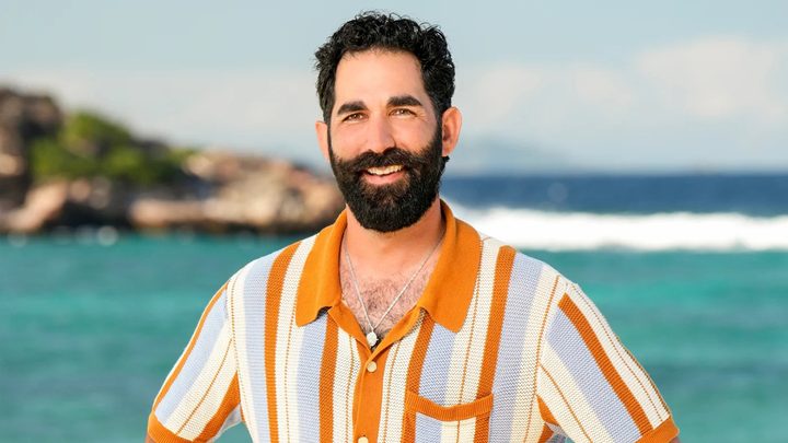 Shauhin on Survivor 48 posing in front of the water on the beach.